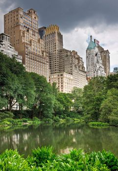 A pond in central park with high rise buildings behind it in New York City