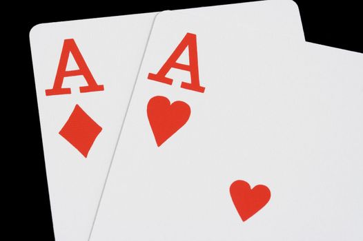 Ace of hearts and Ace of diamonds on black background