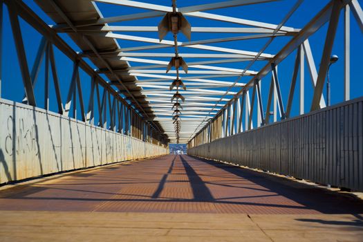 Steel and wooden bridge for pedestrians crossing over the railway tracks
