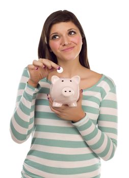 Pretty Smiling Ethnic Female Putting a Coin Into Her Pink Piggy Bank Isolated on a White Background.