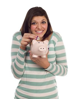 Pretty Smiling Ethnic Female Putting a Coin Into Her Pink Piggy Bank Isolated on a White Background.