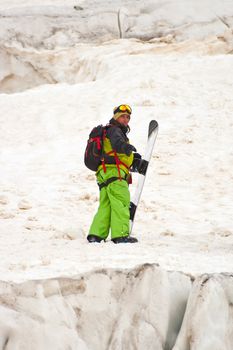 Sportsman in Caucasus mountains with snowboard