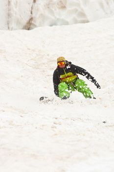 Sportsman in Caucasus mountains with snowboard