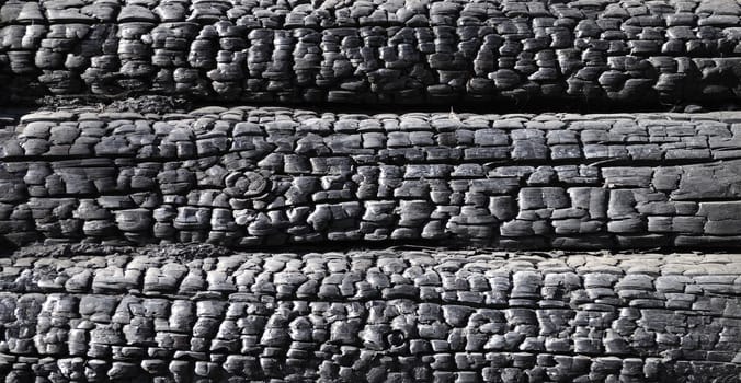 Close up of black burnt log wall background