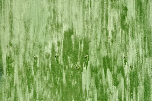 Close up of rough green colored metal background with bolts