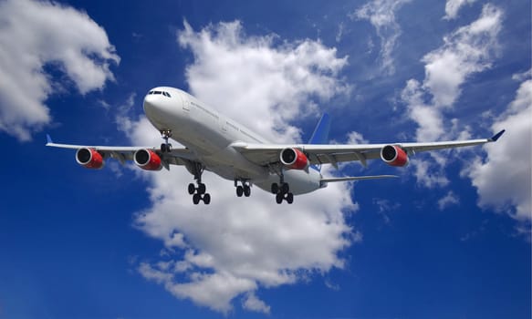 Passenger jet plane going to land  over cloudy blue sky