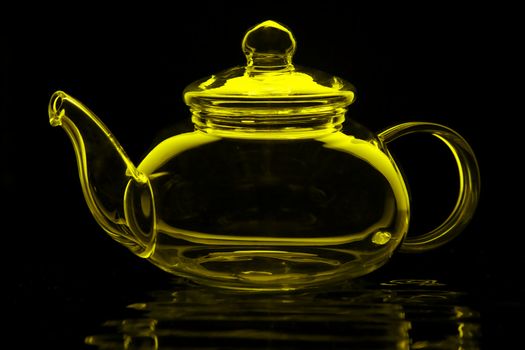 Glass teapot in lime green isolated on black