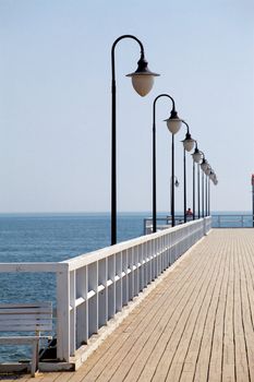 Wooden pier with white benches
