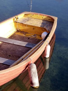 Close up of an old small red boat floating on the water