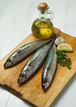 mackerel fish with ingredients on wooden board