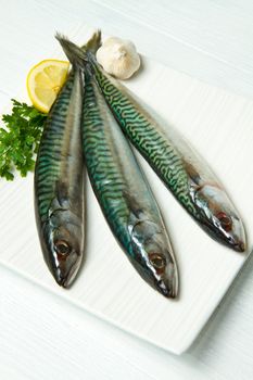 mackerel fish with ingredients on white dish