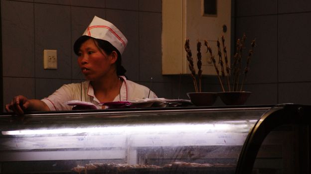 BEIJING AT NIGHT , CHINESE WOMAN BEHIND THE SNACK COUNTER