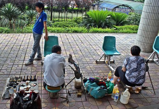 CHINA, CHONGQUIN STREETS, SHOESHINERS