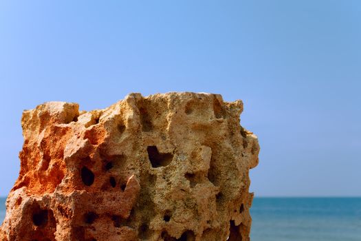 Limestone relief with deep holes on the background sea