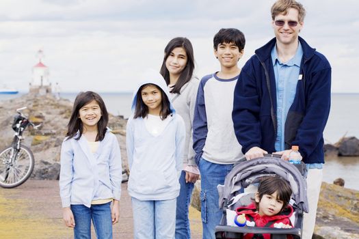 Father with his five children at the beach, interracial family