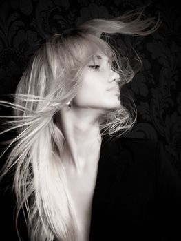 Blond girl swinging long hair, black and white