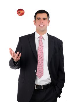 Portrait of a young smiling businessman tossing an apple
