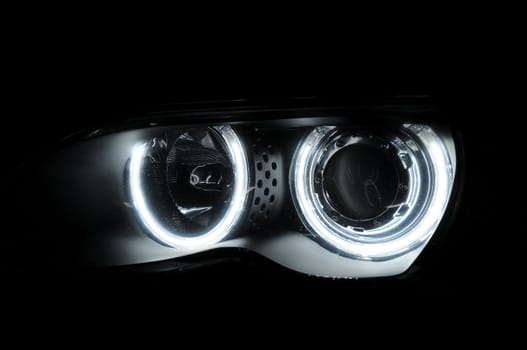 Abstract car circular front lights in darkness