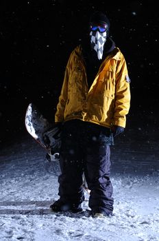 Portrait of a snowboarder standing at night