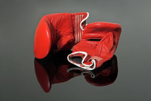 old red boxing gloves on black reflective background