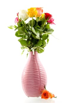 A pink vase with beautiful roses in all kind of colors