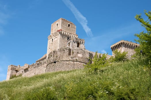 View of the medieval castle of Assisi in Italy on a windy day. Also known as Rocca Maggiore, this castle dominates the town with it's impressive battlements. The earliest records of the current castle date back to the year 1174.