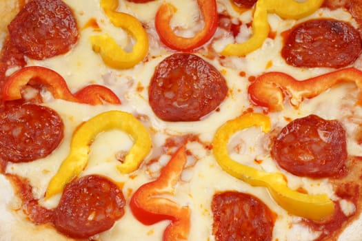 Full frame of original italian pizza with mozzarella tomato, hot spicy salami and red and yellow bell peppers.