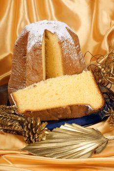 Christmas composition with Pandoro the golden cake of Verona and some ornaments over a yellow background