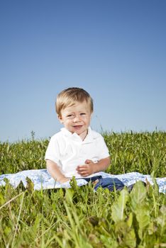 Child sitting in the grass on a sunny day