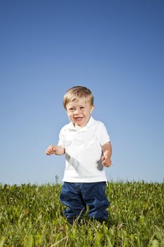 Young boy standing in the grass