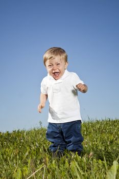 Crying child standing in the grass