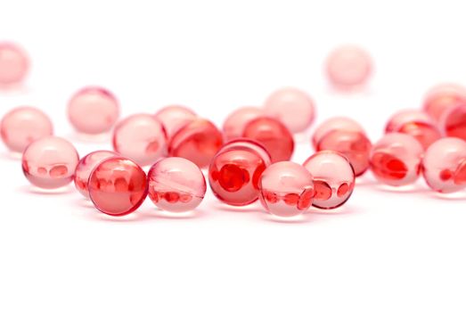 Transparent red capsules isolated on white