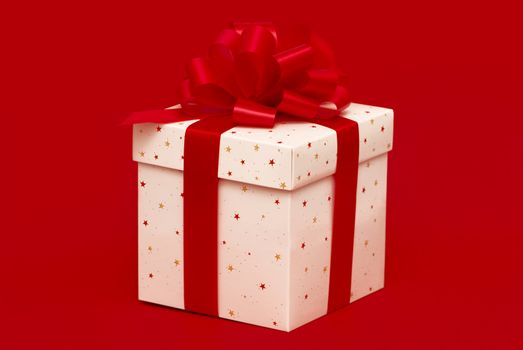 Christmas gift with red ribbon isolated on red background