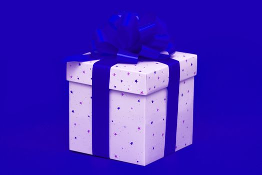 Christmas gift with blue ribbon isolated on red background