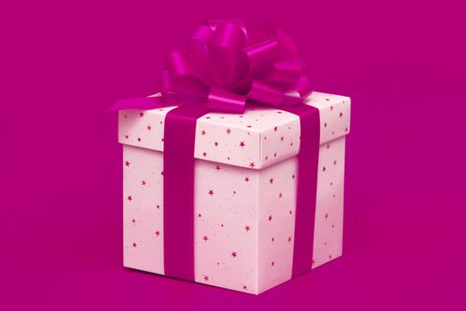 Christmas gift with purple ribbon isolated on red background