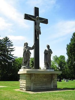 Photo of statue depicting the Virgin Mary and Mary Magdalene standing near Jesus Christ on the cross.

