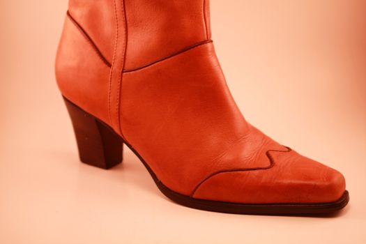 Brown cowboy boot with wooden heel and brown trim on soft background. Cowboys, cowgirl and western active wear, footwear, shoes and clothing.