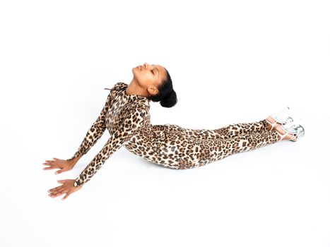 African dancer in a leopard suit striking a pose on the floor