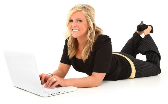 Beautiful 20 year old American woman laying on white with white laptop.