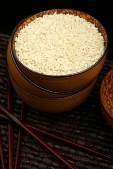 Raw arborio rice in a brown bowl in kitchen setting.