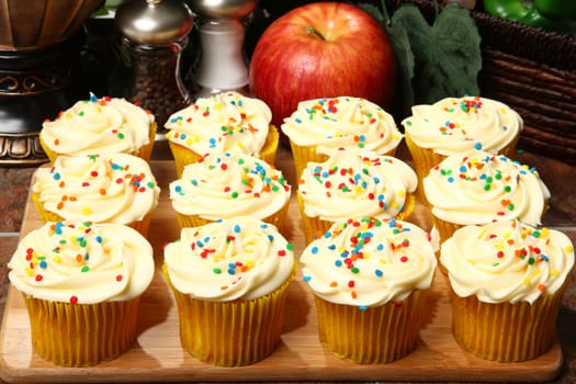 Tray of cream cheese cupcakes on kitchen counter.