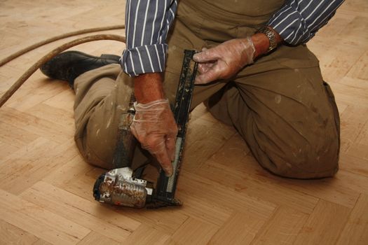 Refilling an electric stapler while laying a wooden floor