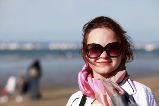 The happy girl in solar glasses on a beach