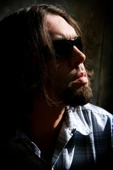 Long haired man with sunglasses in a low key shot