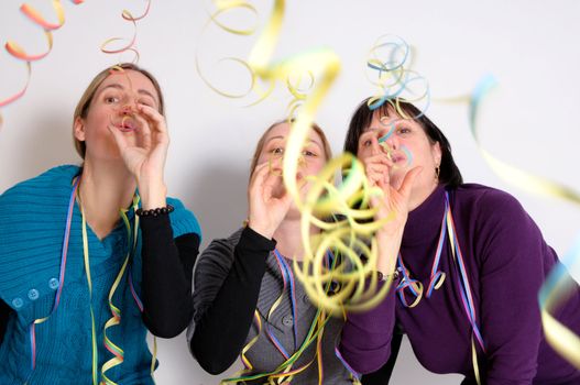 Two young women and one senior woman celebrating New year's eve. Shot taken in front of white background