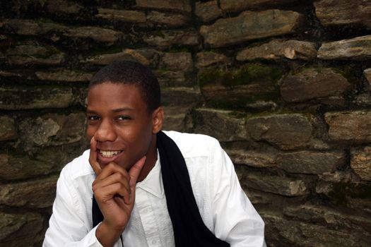 A man in front of mossy wall smiling