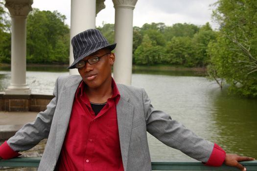 A homosexual man posing in front of a lake