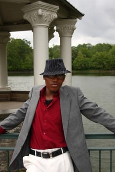 A homosexual man posing in front of a lake