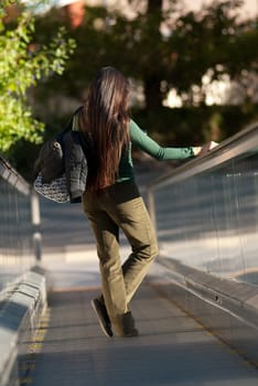 Trendy urban girl usinga an outdoor escalator in a park