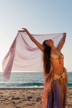 Sexy oriental dancer spreading her arms with a headscarf